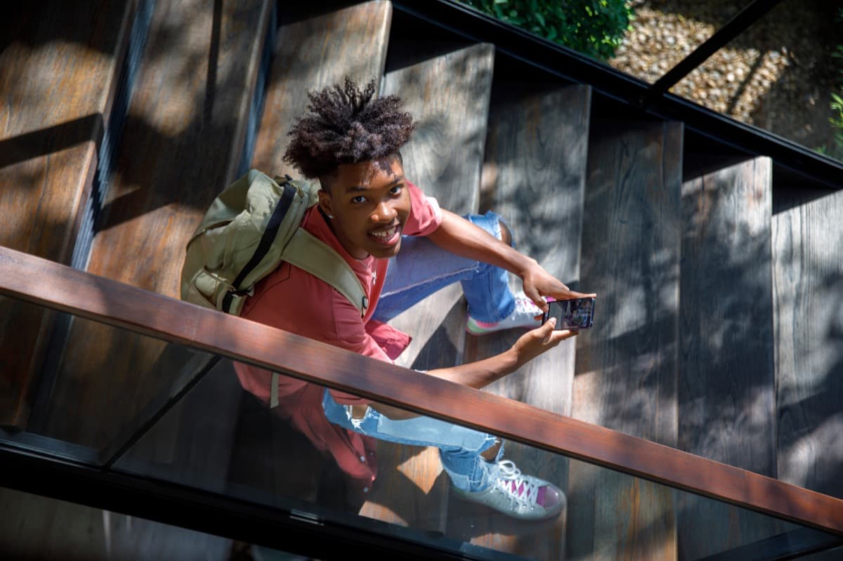 A student smiling on a set of outdoor stairs